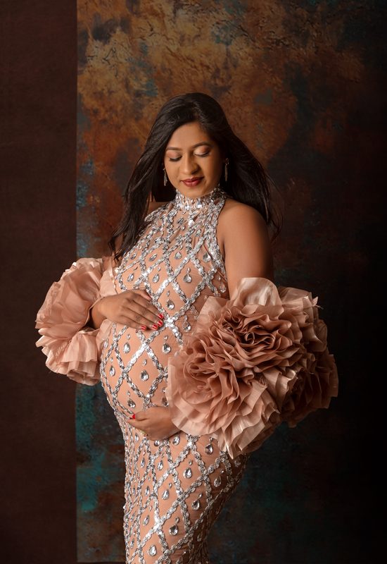 Maternity portrait in a sequinned gown with blush ruffled sleeves